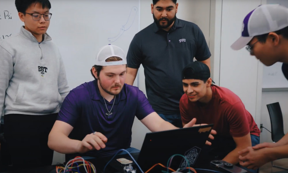 Students gathered around a laptop