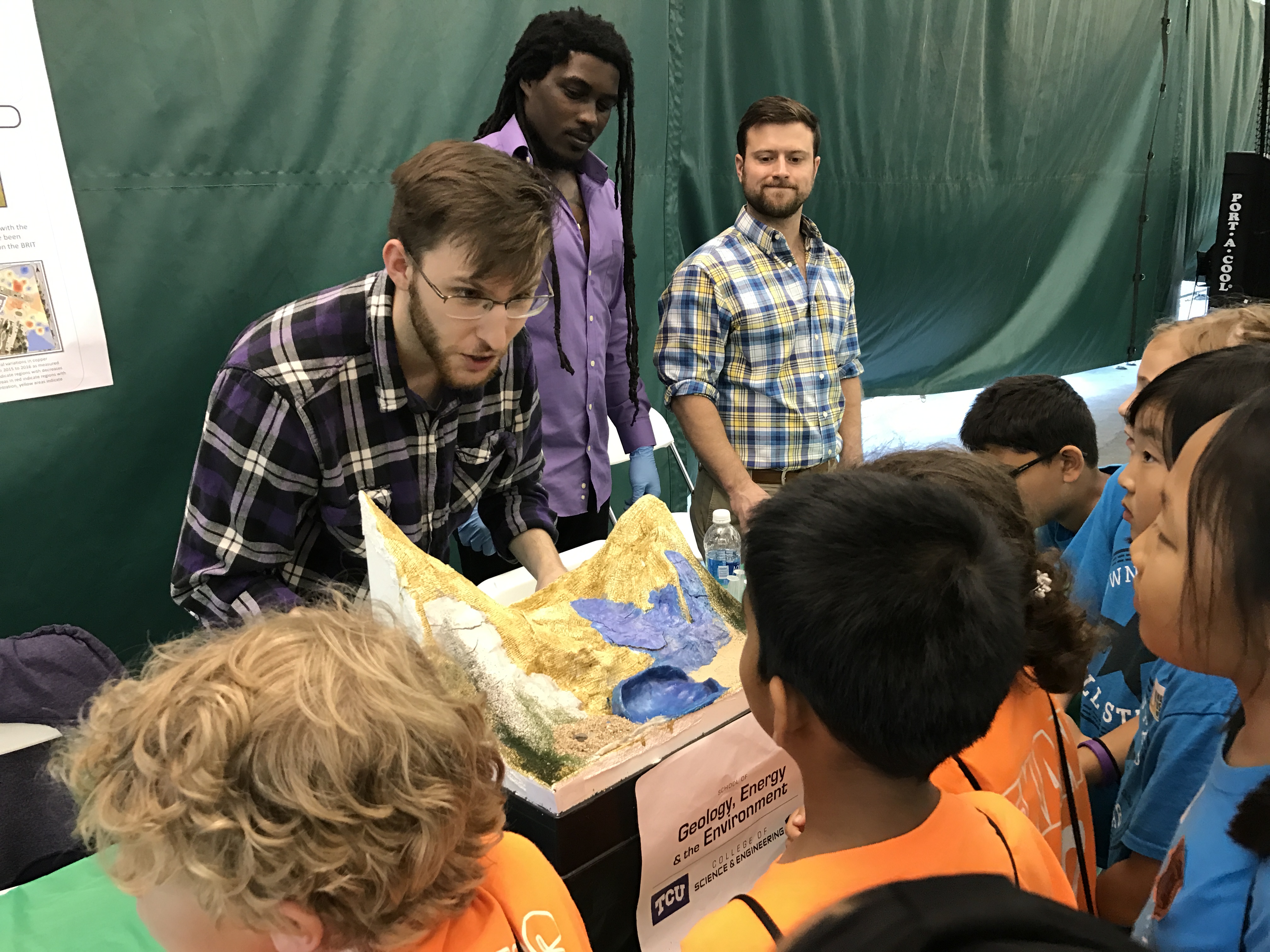 A geologist talks to a small group of science fair attendees